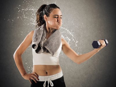 sweating woman lifting dumbbell